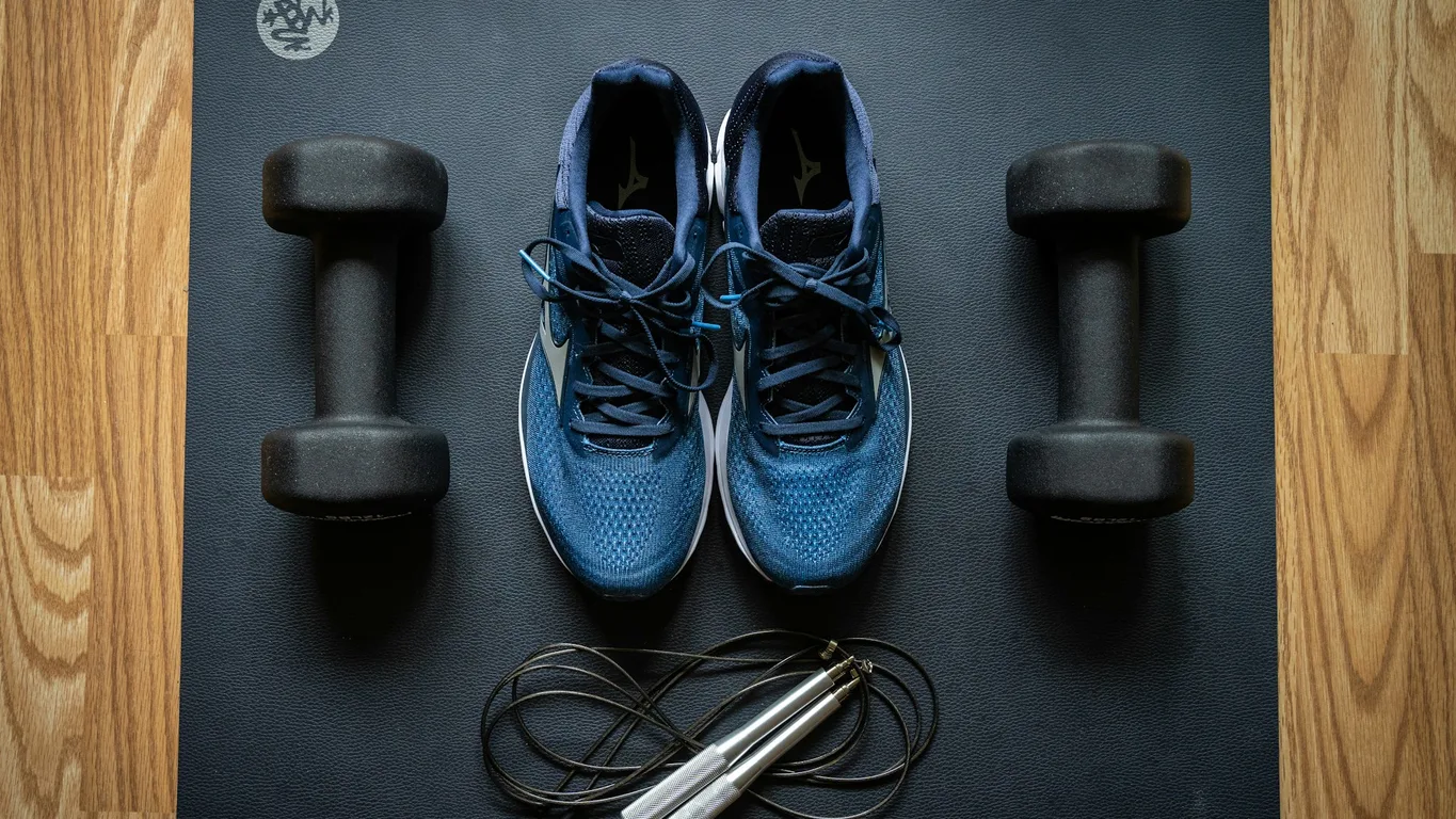 Laufschuhe und Kettlebell nebeneinander auf Gym-Boden von oben