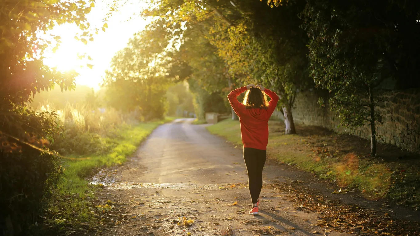 Fitness-Tracker, Kaffeetasse, Schlüssel und Sonnenbrille auf Holztisch nach einem Spaziergang