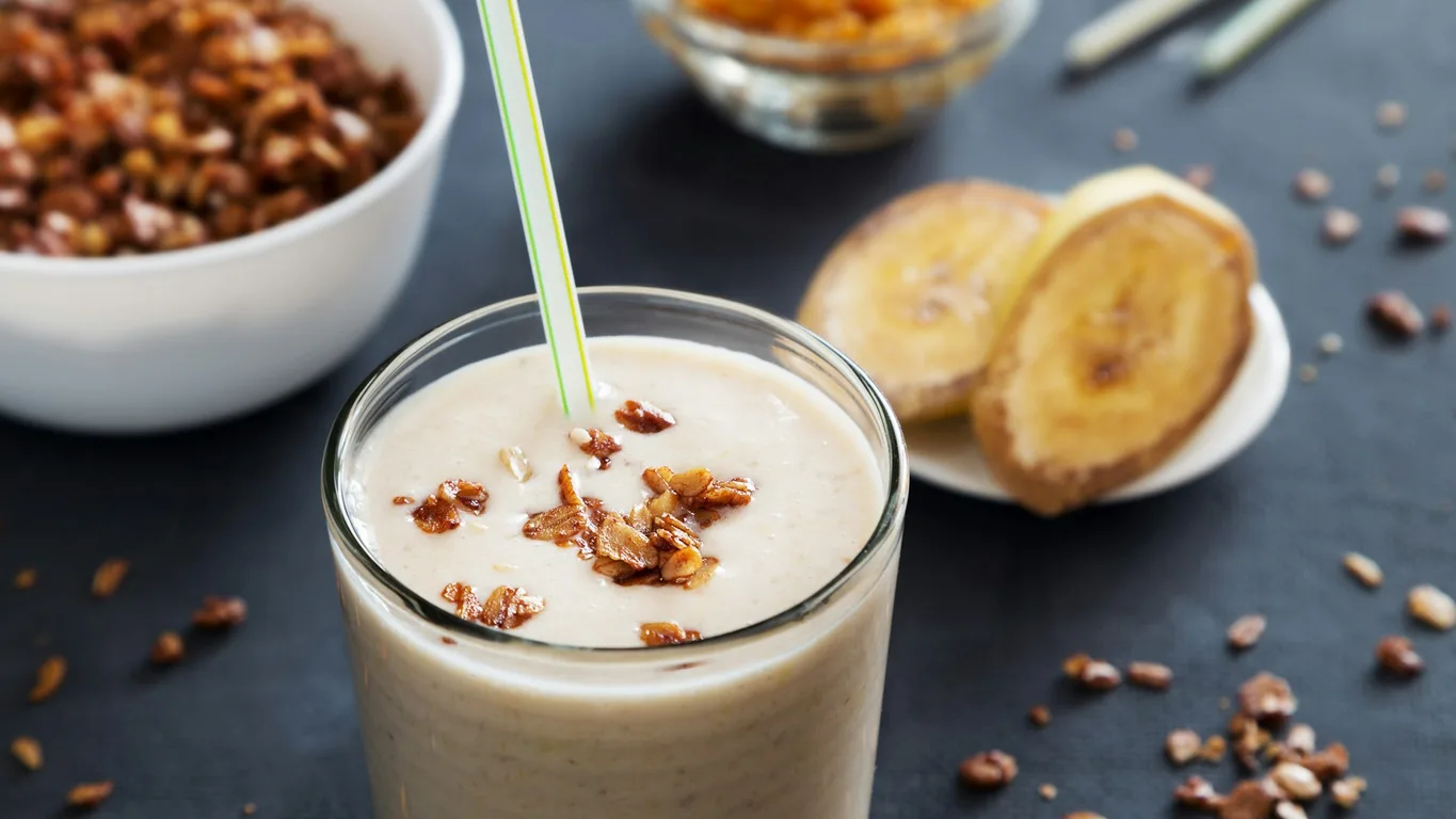 Protein-Shaker und Wecker im Morgenlicht auf einer Küchenarbeitsplatte