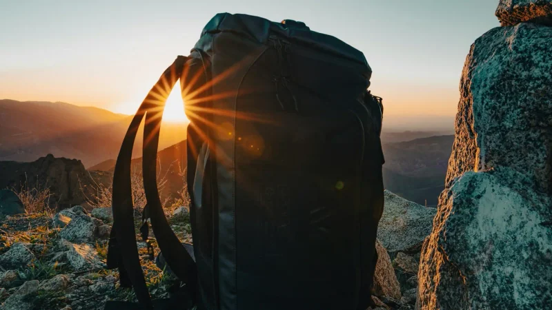 Rucksack zwischen Felsen im Licht der tief stehenden Sonne.
