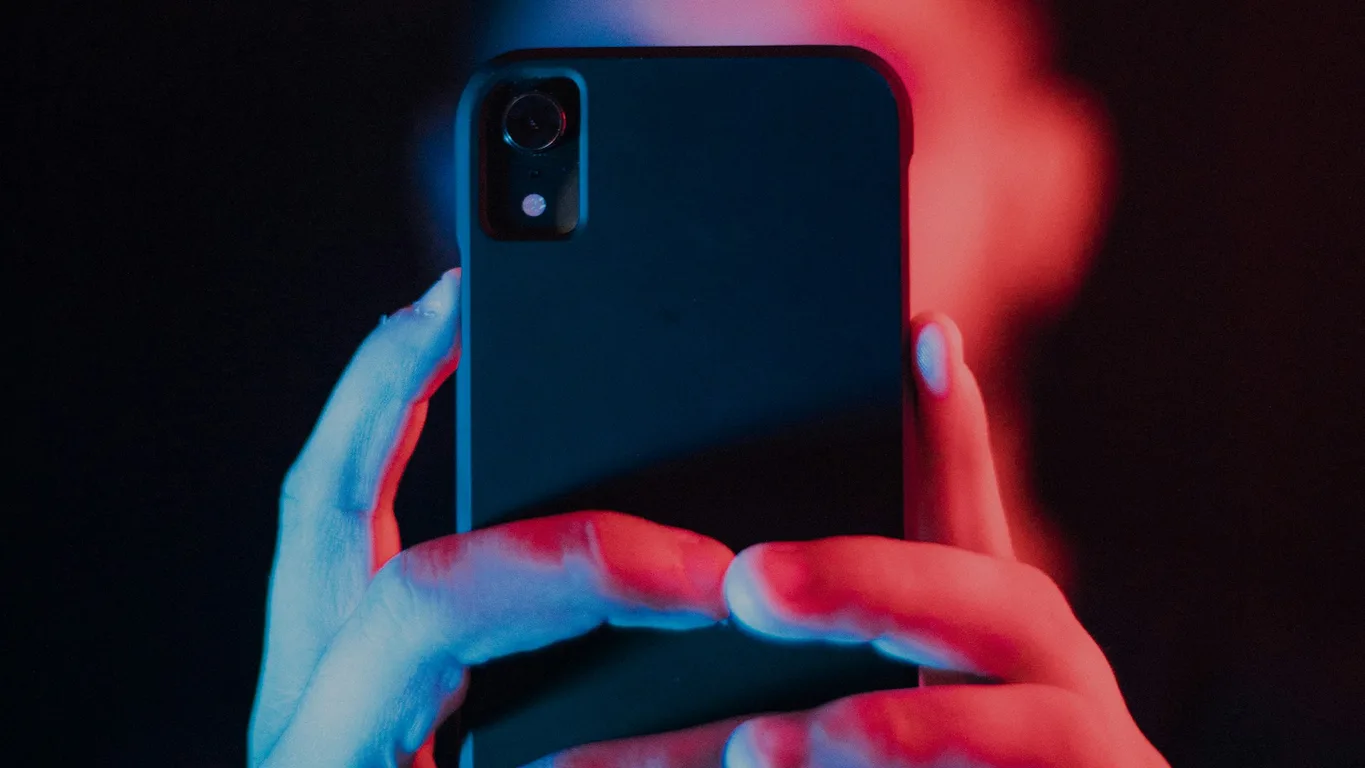 Smartphone mit Schloss-Symbol auf Holztisch, warmes Fensterlicht