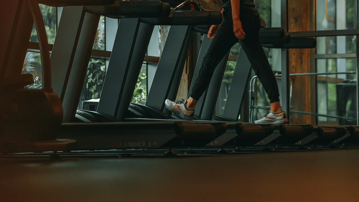 Frau fährt entspannt auf einem stationären Bike im Gym, warmes Spotlight